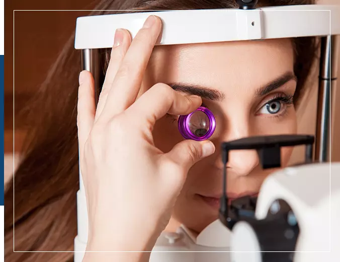 A woman is looking through the lens of an eye test.