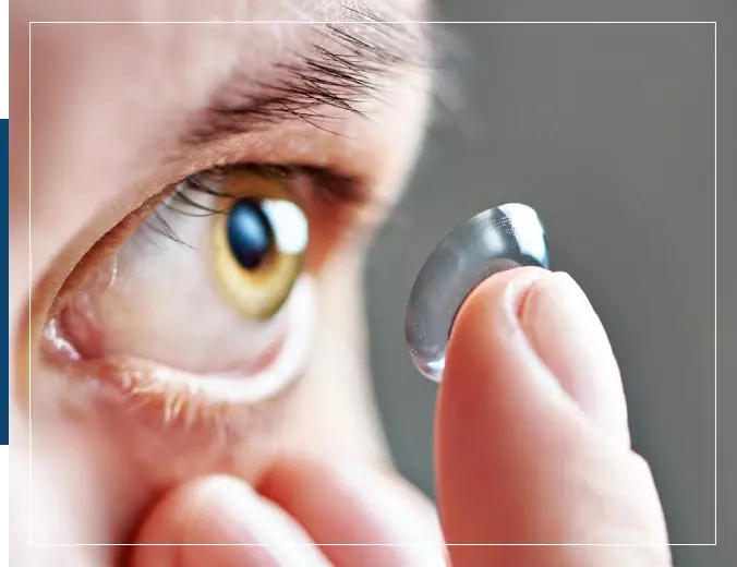 A person holding an eye glass in their hand.